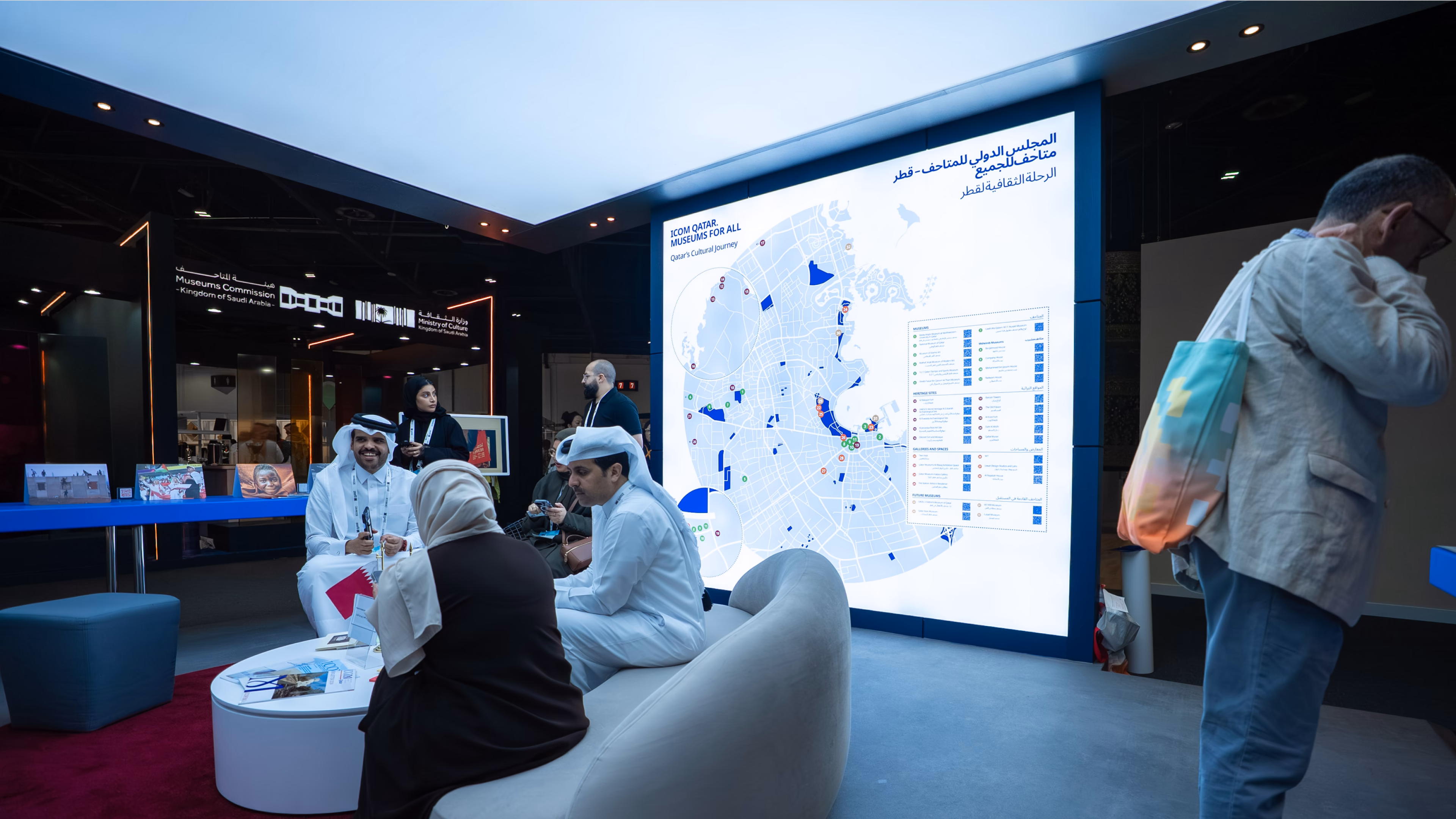 Bezoekers verzameld rond de grote verlichte kaart van Qatar op de ICOM Qatar-beursstand